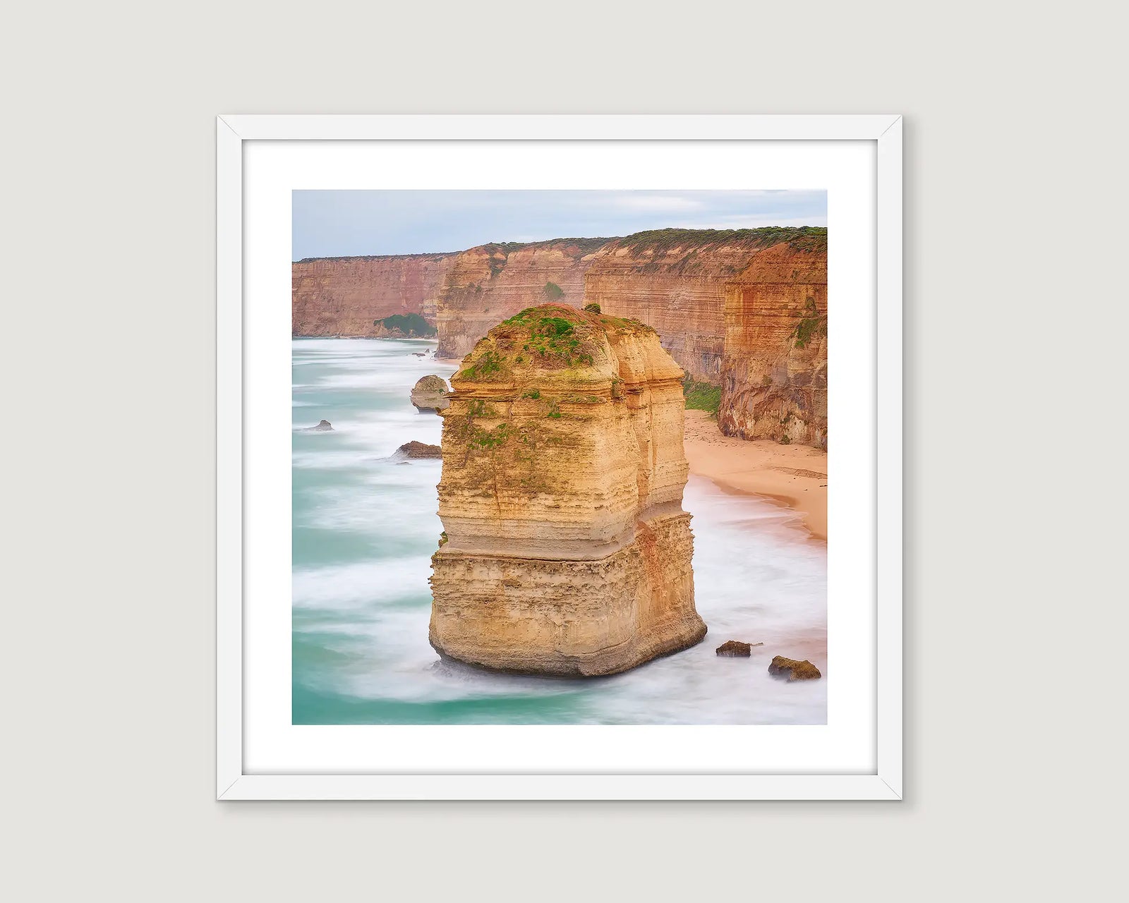 Framed photograph of a rock formation of the Twelve Apostles and cliffs and ocean.