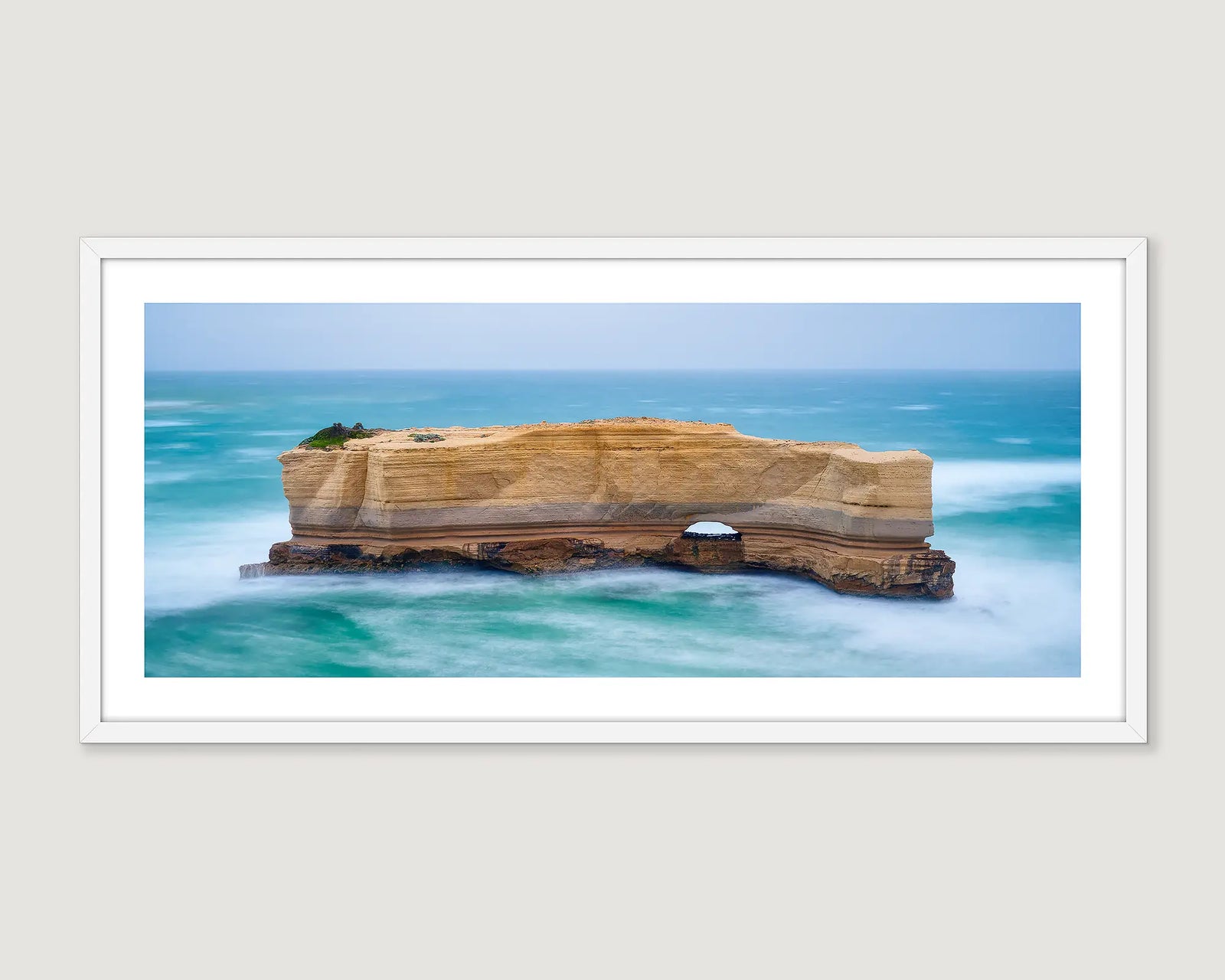 Framed photograph of a coastal landscape with a rock formation and ocean on the Great Ocean Road.