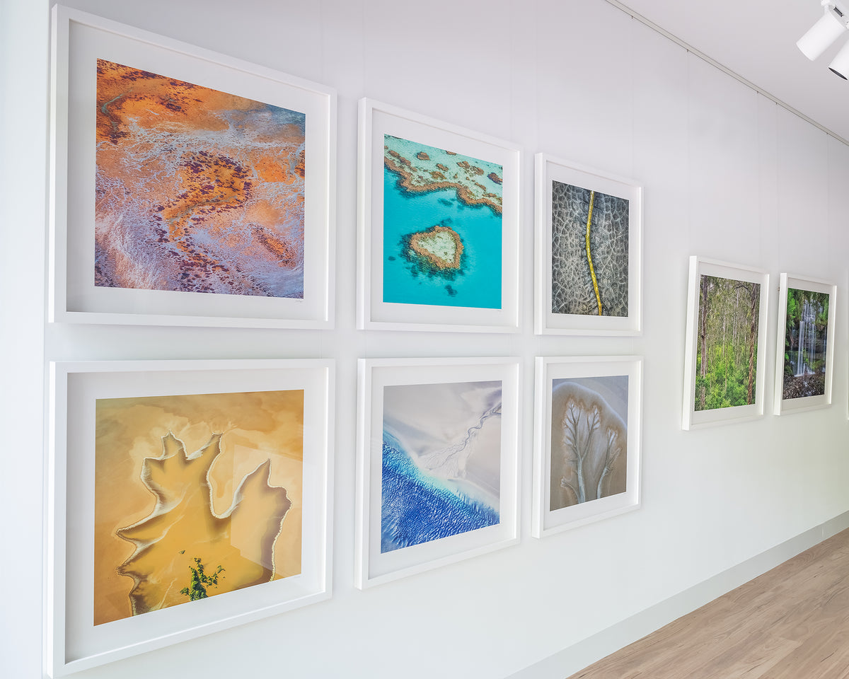 The Chase. Abstract artwork of tidal patterns, The Kimberley, with white frame on display in gallery.