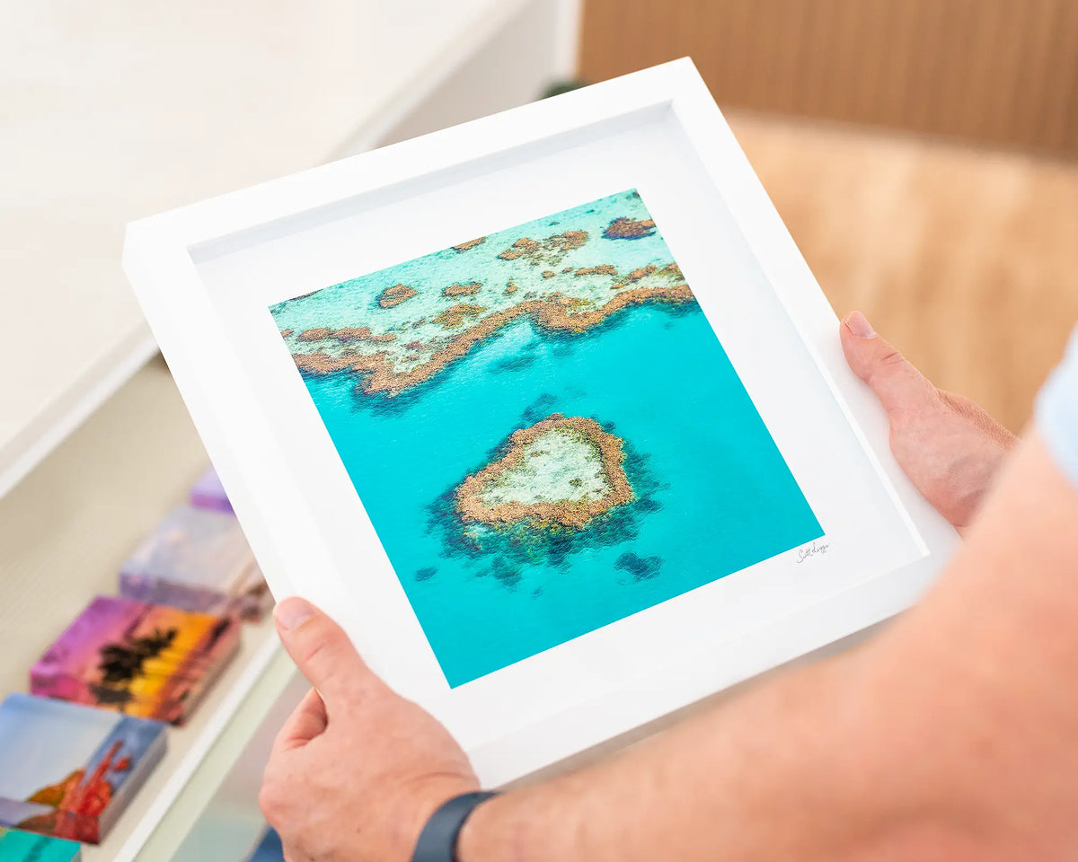 The Heart. Coastal artwork of Heart Reef, Great Barrier Reef, Queensland with small framed print in white frame.