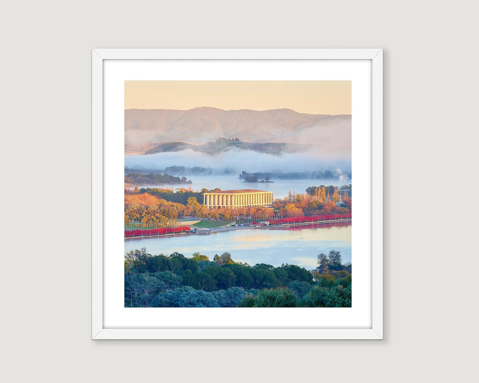 Framed artwork of a scenic landscape with The National Library of Australia, a lake and mountains.