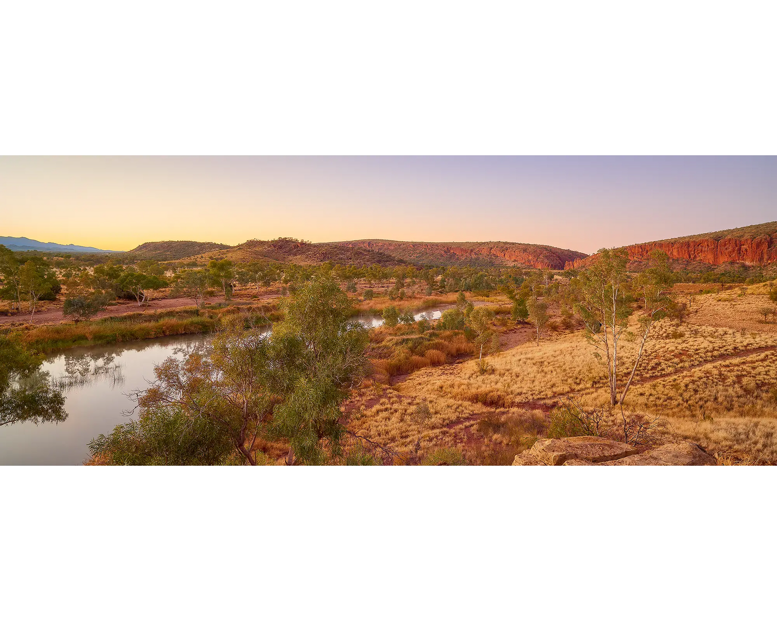 Framed photograph of the outback and the Finke River under a blue sky.