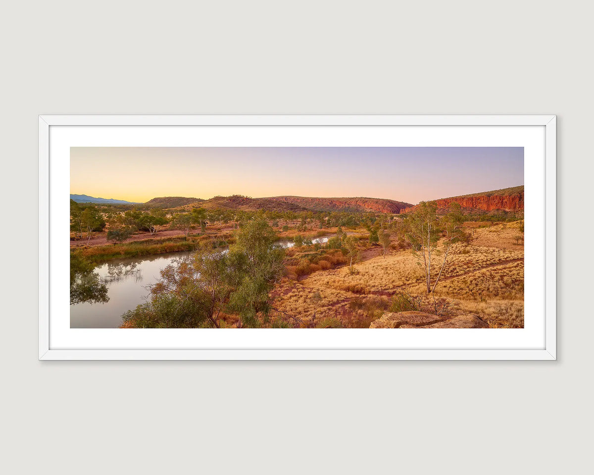 Framed photograph of the outback and the Finke River under a blue sky.