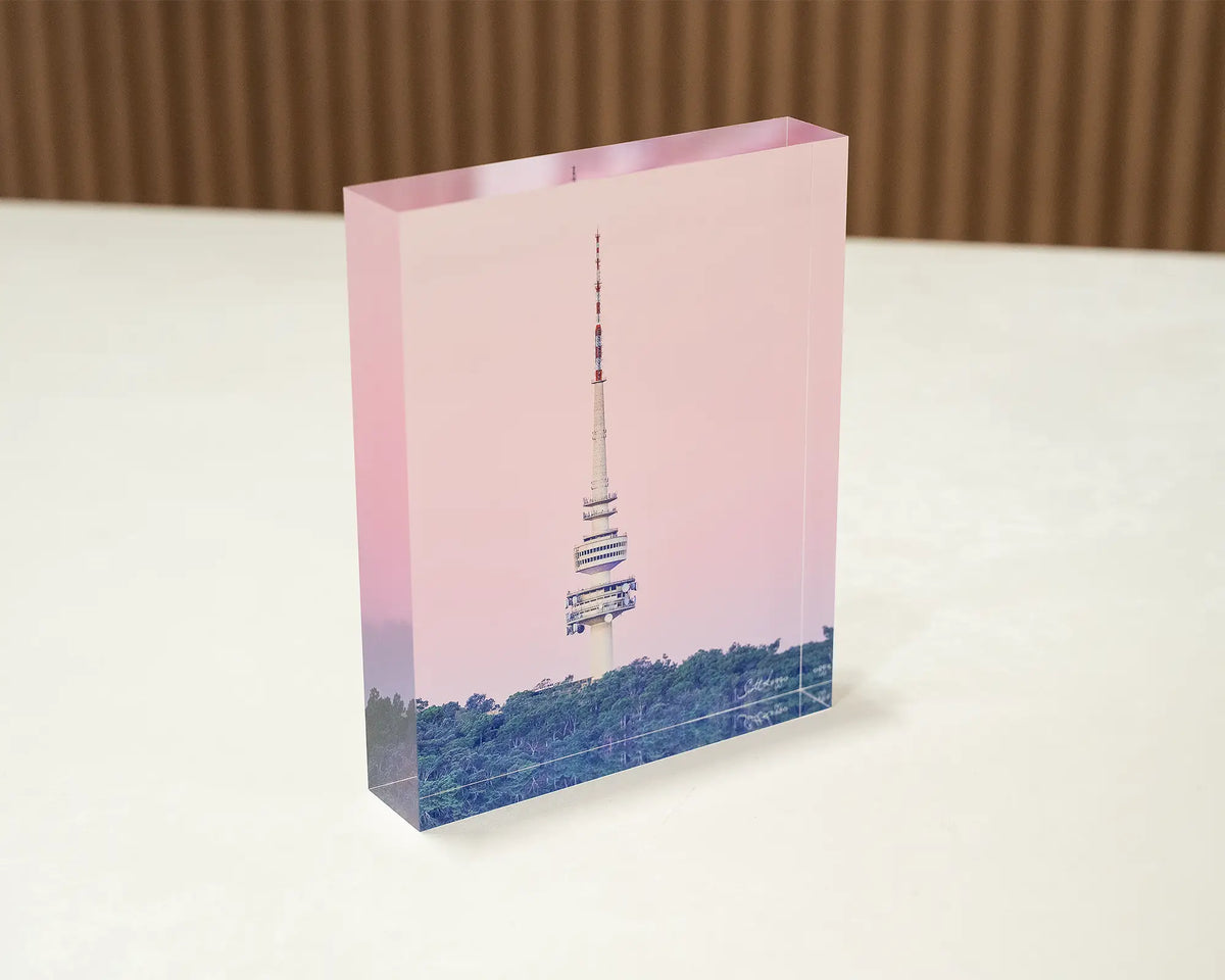 The Needle. Acrylic block of Telstra Tower Canberra with pink sunset, sitting on a desk.
