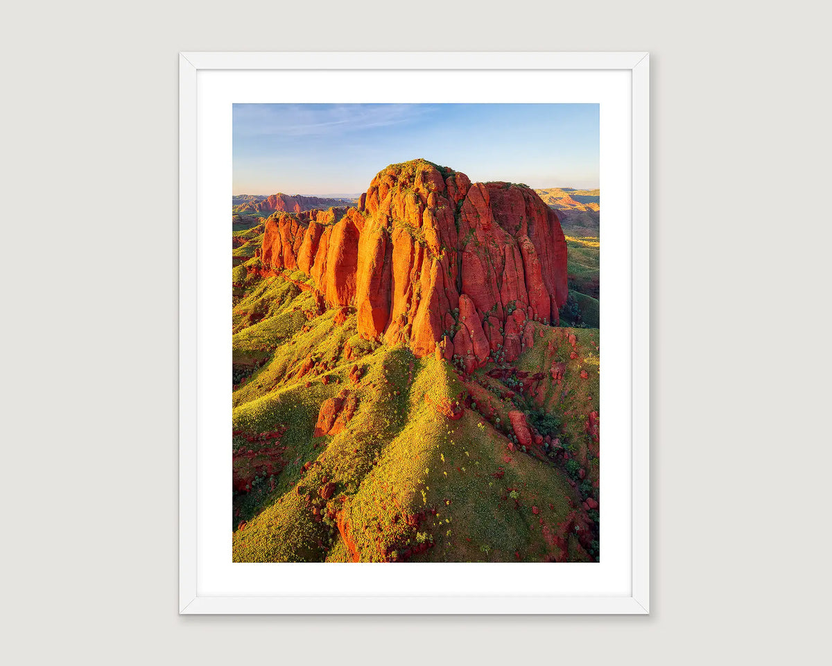 Framed artwork of a scenic landscape in the Kimberley with red rock formations and greenery.