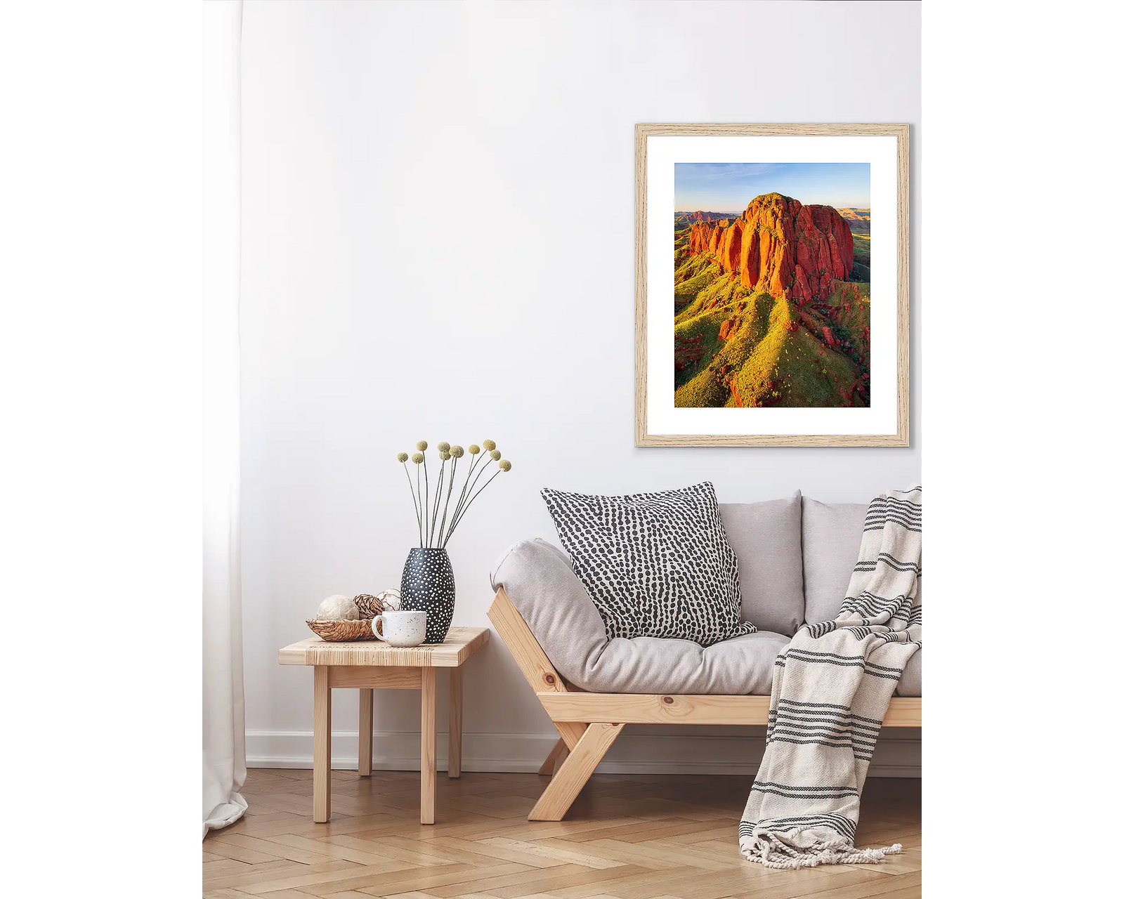 Framed artwork of a scenic landscape in the Kimberley with red rock formations and greenery.