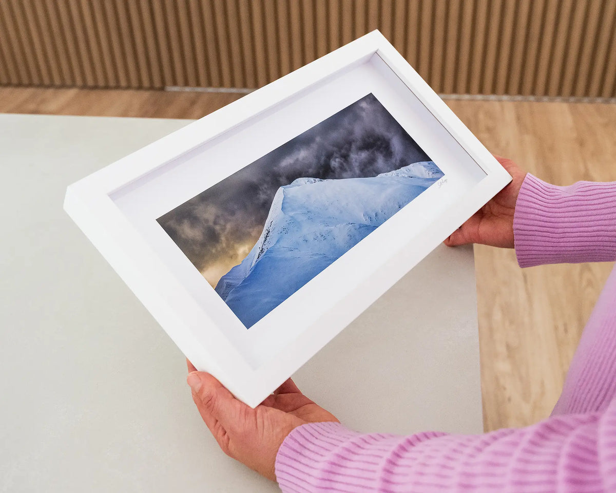 The Summit. Small print with white frame of Mount Feathertop, Victoria, held in hands.
