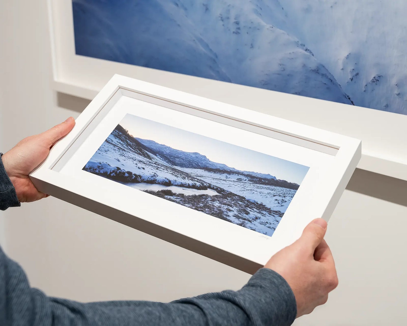 Framed photograph of a snowy Thredbo landscape with a river and mountains.