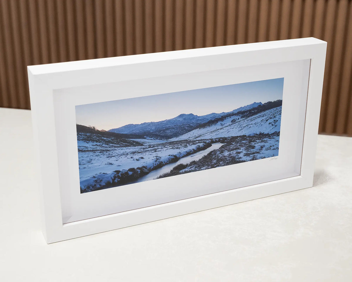 Thredbo Colours. Small framed print of sunset over Thredbo river sitting on a desk.