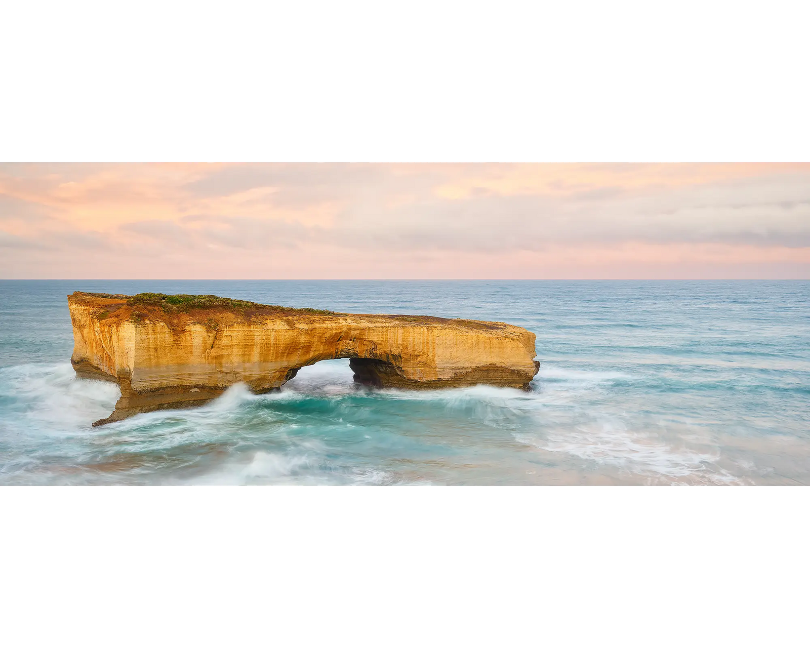Time Out. London Bridge on the Great Ocean Road, with a pink sunrise.