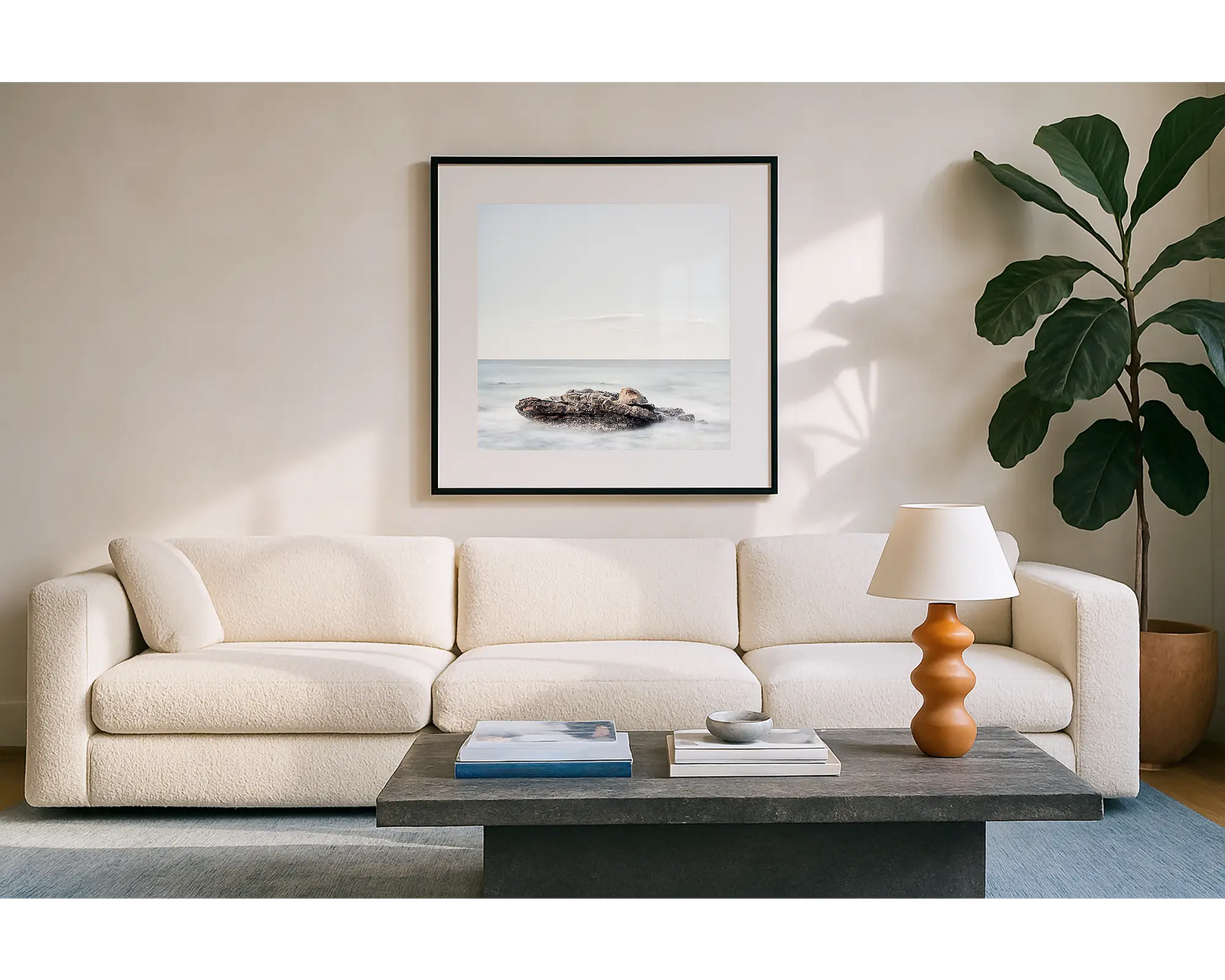 Framed photograph of a rock in the ocean with a white frame.