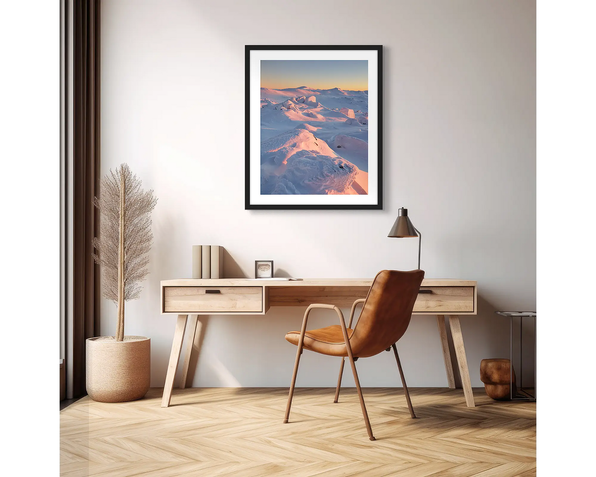 Tones of Kosciuszko. Wall art print of a sunrise over Mount Kosciuszko framed with a black frame and hung in an apartment above a desk. 