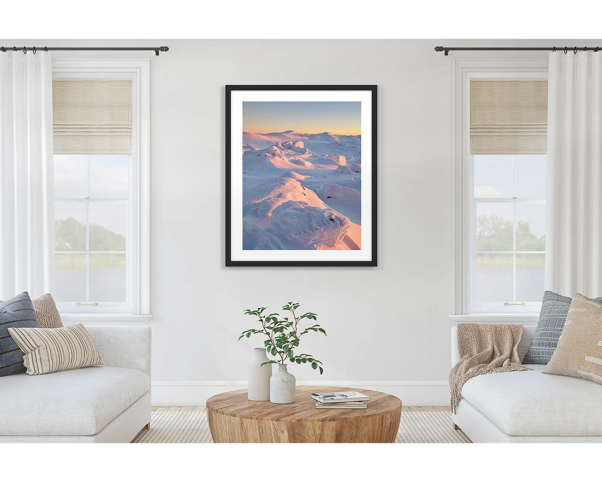 Tones of Kosciuszko. Wall art print of a sunrise over Mount Kosciuszko framed with a black frame and hung on a lounge room wall. 