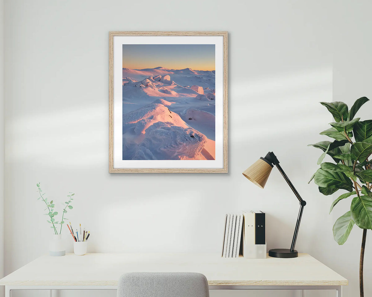 Tones of Kosciuszko. Wall art print of a sunrise over Mount Kosciuszko framed with a timber frame and hung above a small desk. 