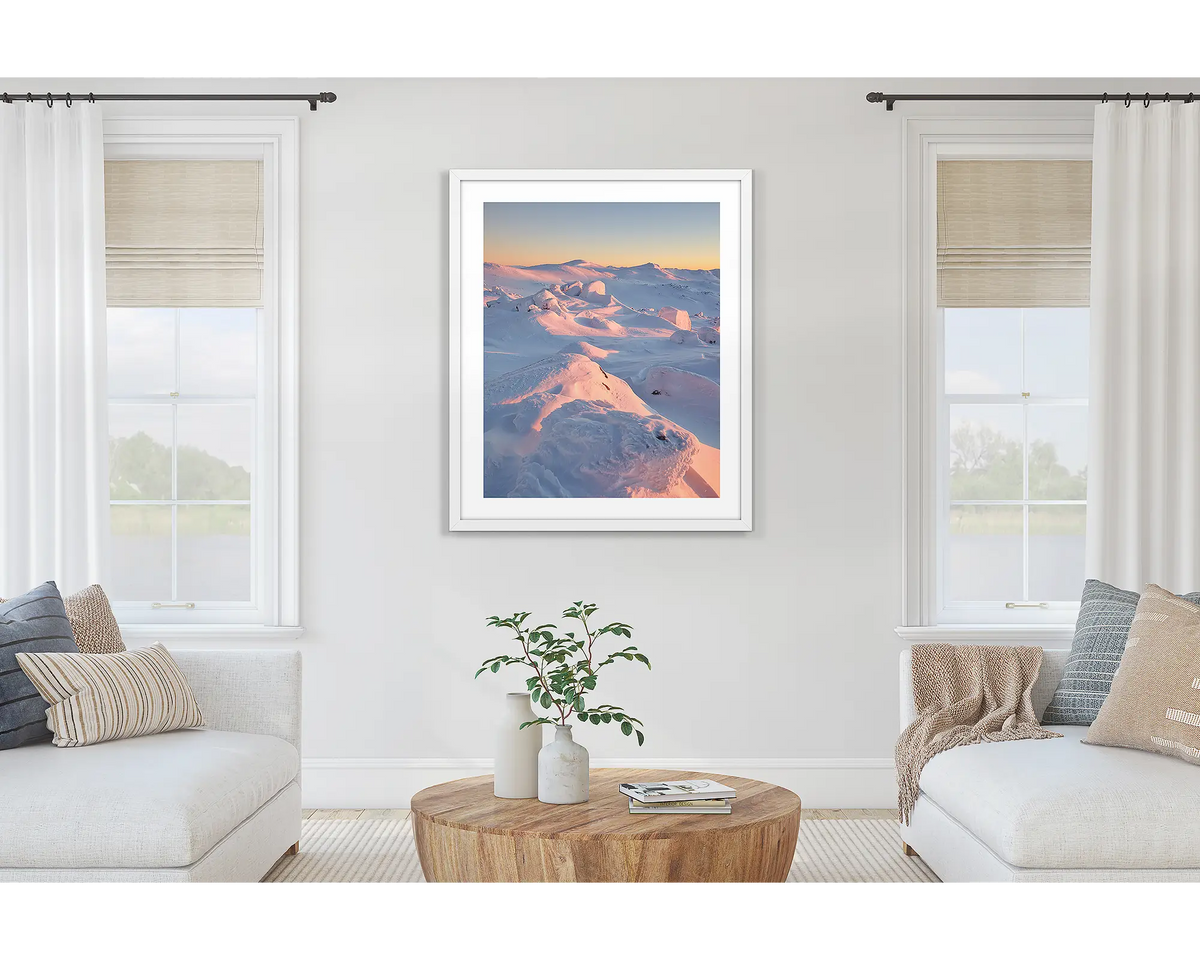 Tones of Kosciuszko. Wall art print of a sunrise over Mount Kosciuszko framed with a white frame and hung on a lounge room wall. 