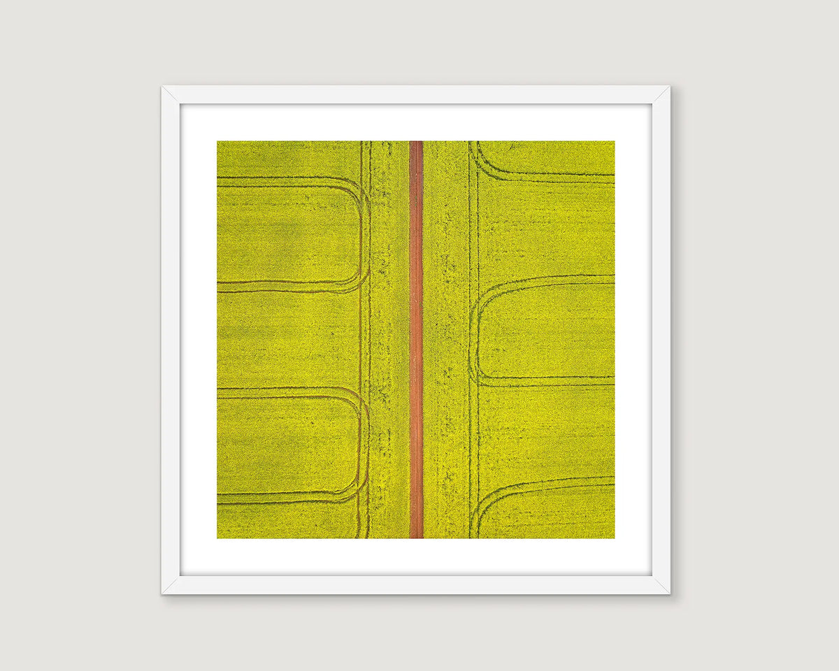 Framed abstract art with a yellow background and red line on a white wall
