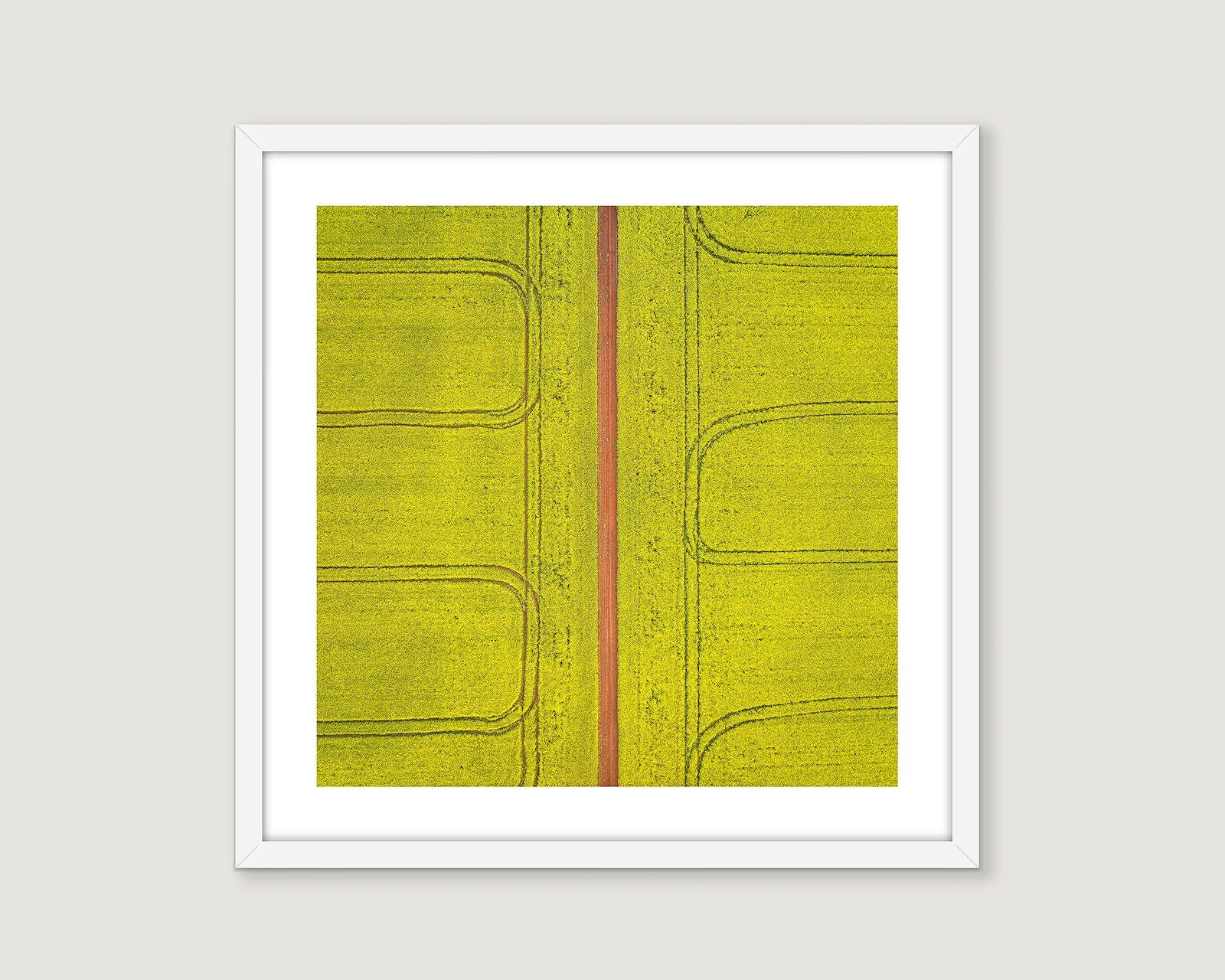 Framed abstract art with a yellow background and red line on a white wall