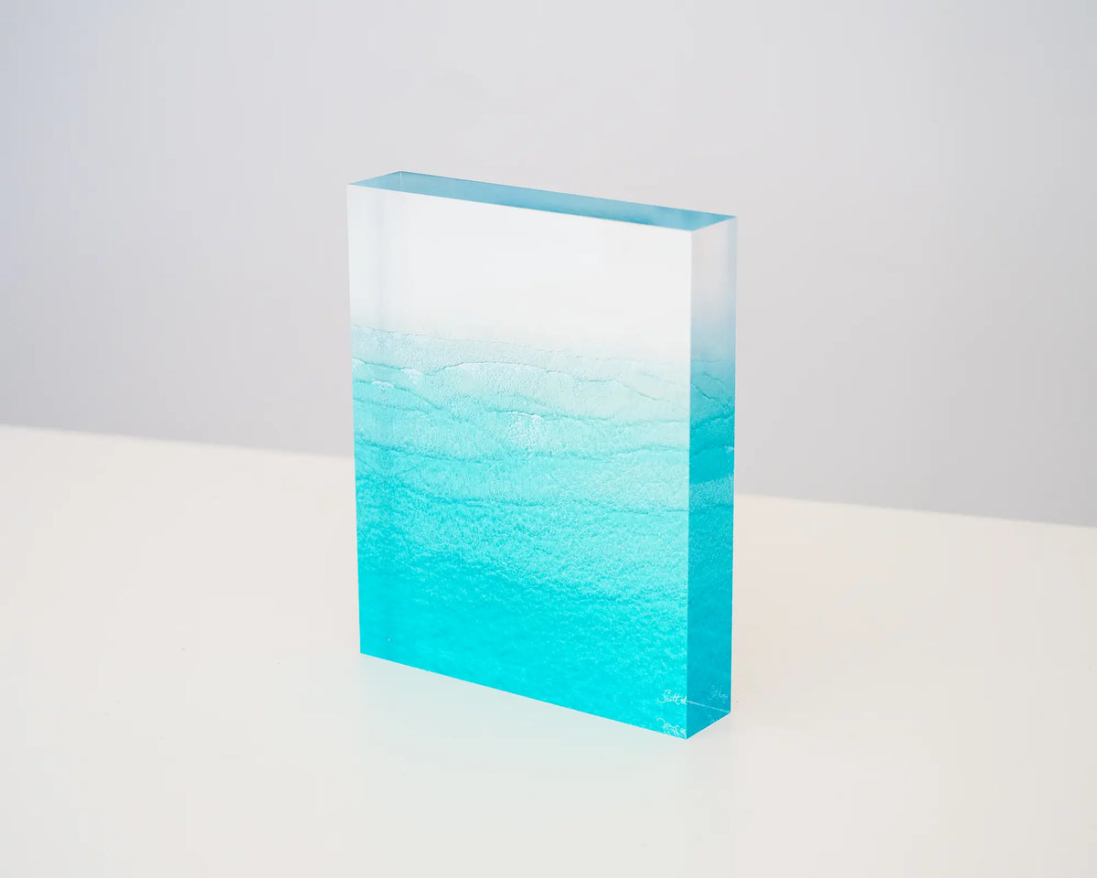 Tranquility. Acrylic block of Whitehaven Beach, Queensland aerial image, sitting on a desk.