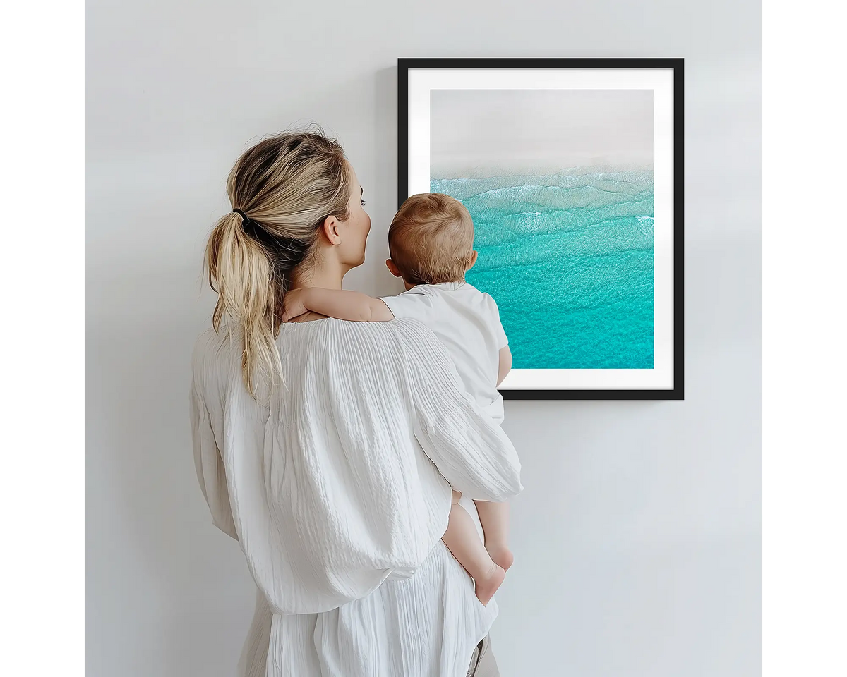 Tranquility. Aerial photography artwork of Whitehaven Beach, with a black frame, being admired by a mother and baby. 