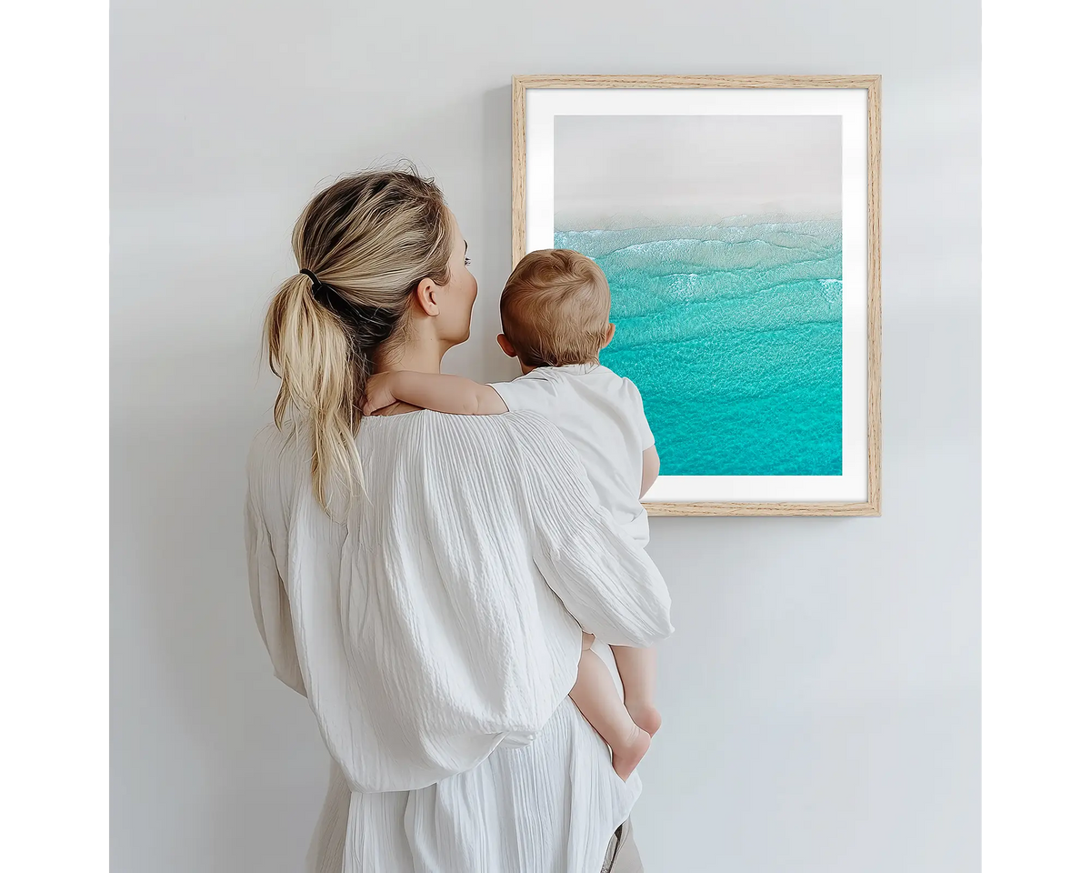 Tranquility. Aerial photography artwork of Whitehaven Beach, with a timber frame, being admired by a mother and baby. 
