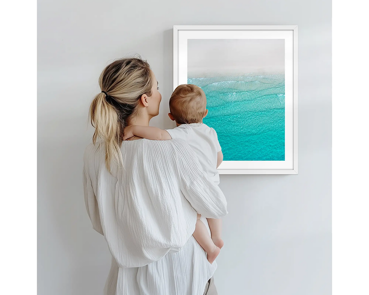 Tranquility. Aerial photography artwork of Whitehaven Beach, with a white frame, being admired by a mother and baby. 