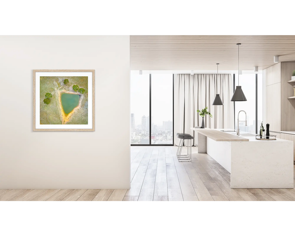 Trigonous. Framed wall art print of a farm dam, in Brindabella Valley, with a timber frame hung on a hallway wall. 
