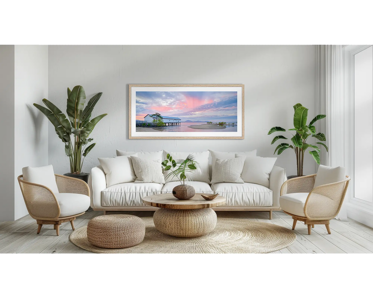 Twilight Blush. Wall art print of a pink sunset over Port Douglas, framed in a timber frame and hung on a lounge room wall. 