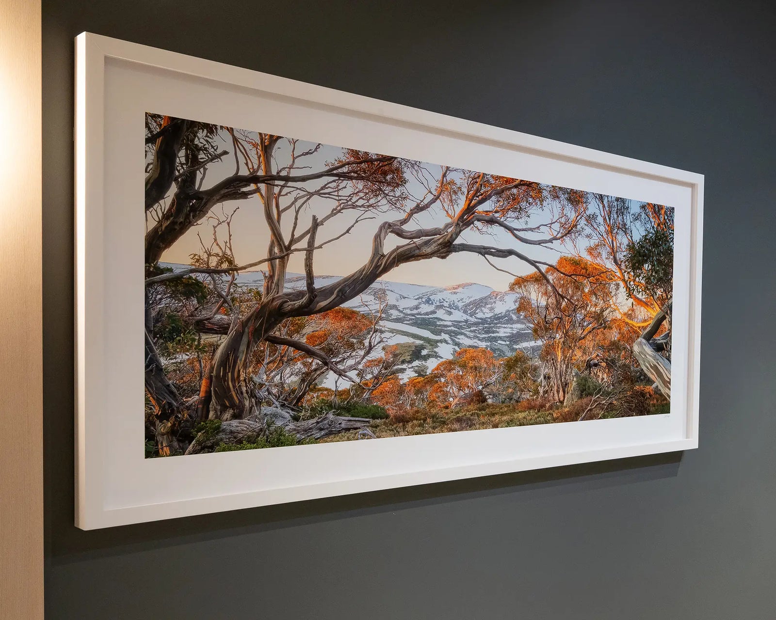 Framed artwork of a scenic landscape towards Twynams Peak with trees and mountains.