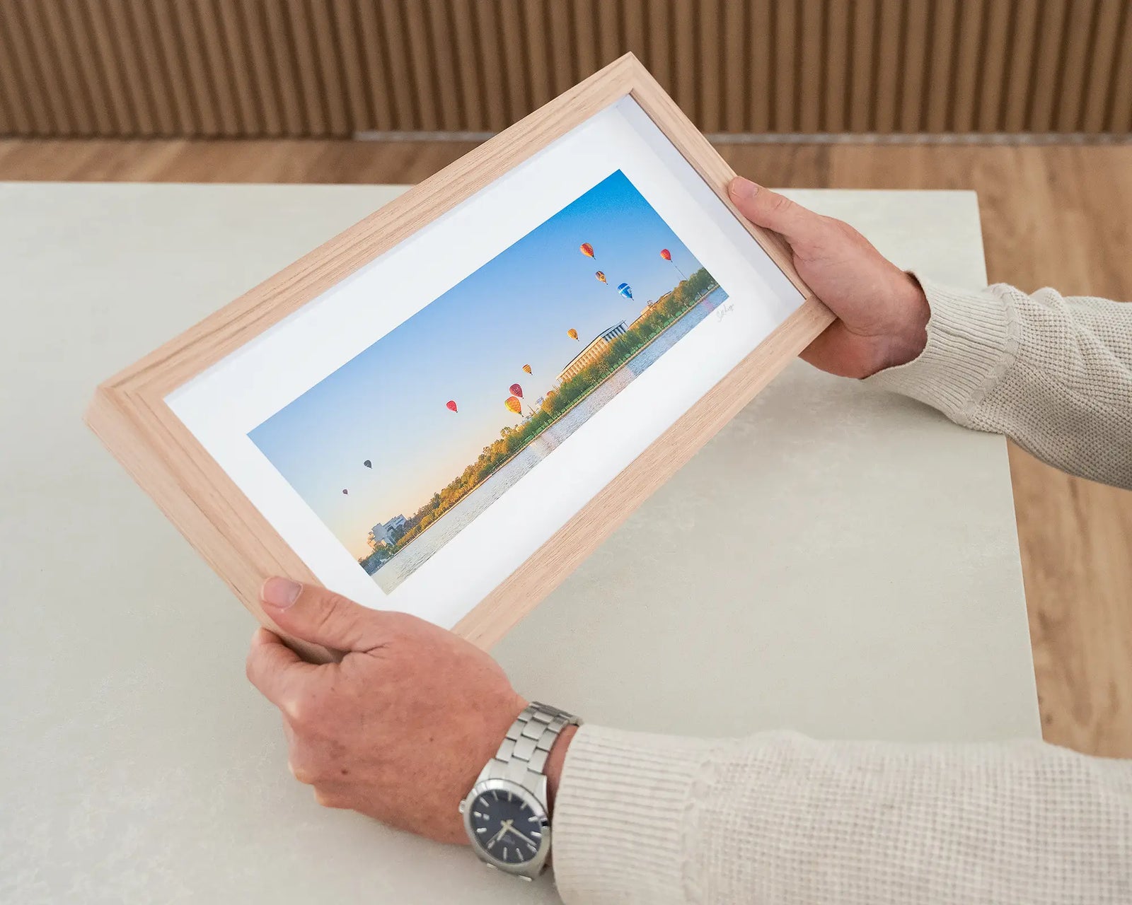 Framed artwork of hot air balloons over Lake Burley Griffin with buildings in the background.