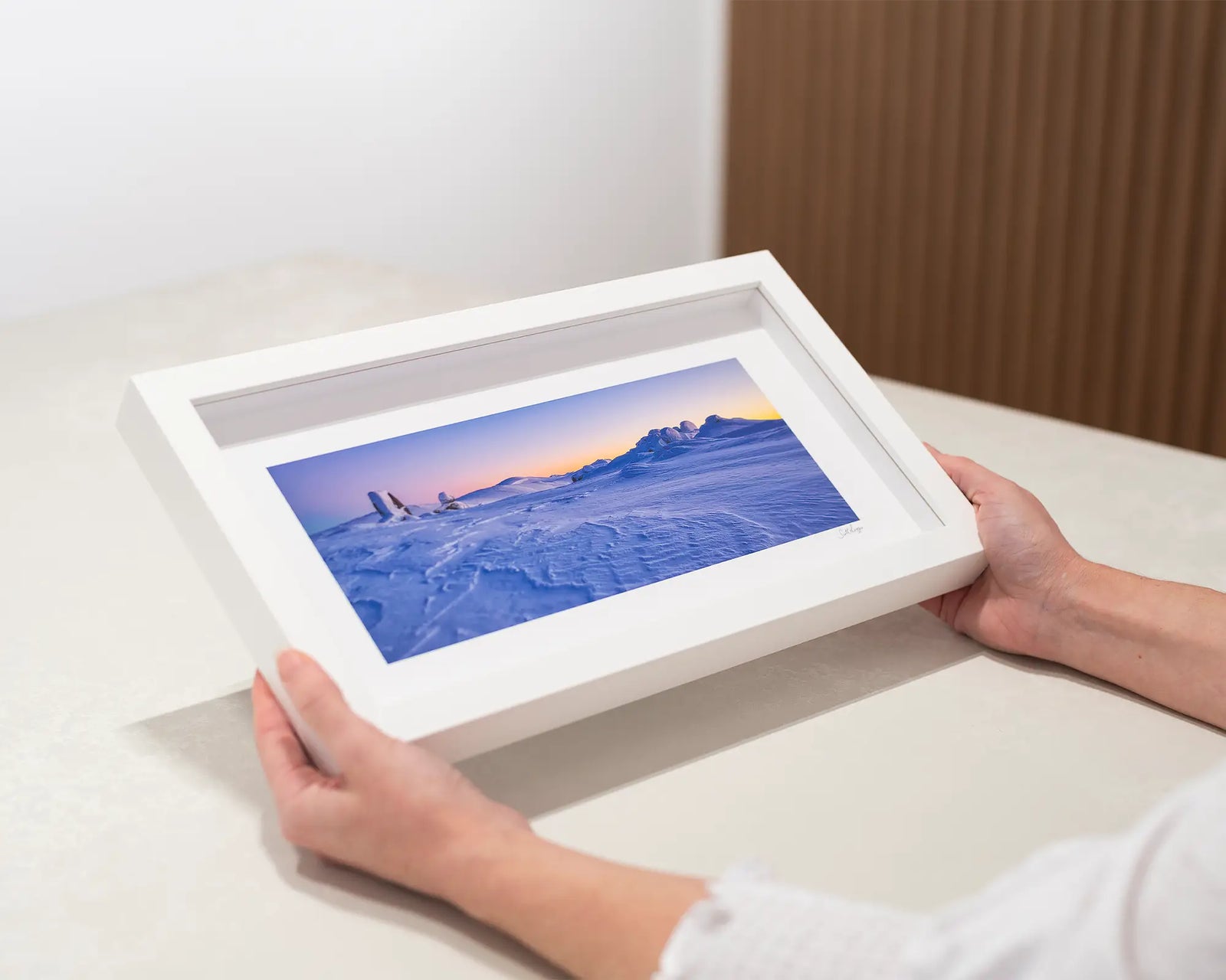 Framed photograph of a snowy Rams Head Range and Main Range landscape with a sunrise.