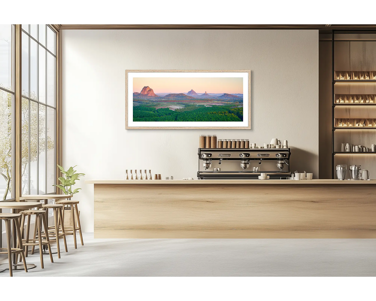Volcanic Dawn. Glasshouse Mountains wall art print with a timber frame hung in a cafe. 
