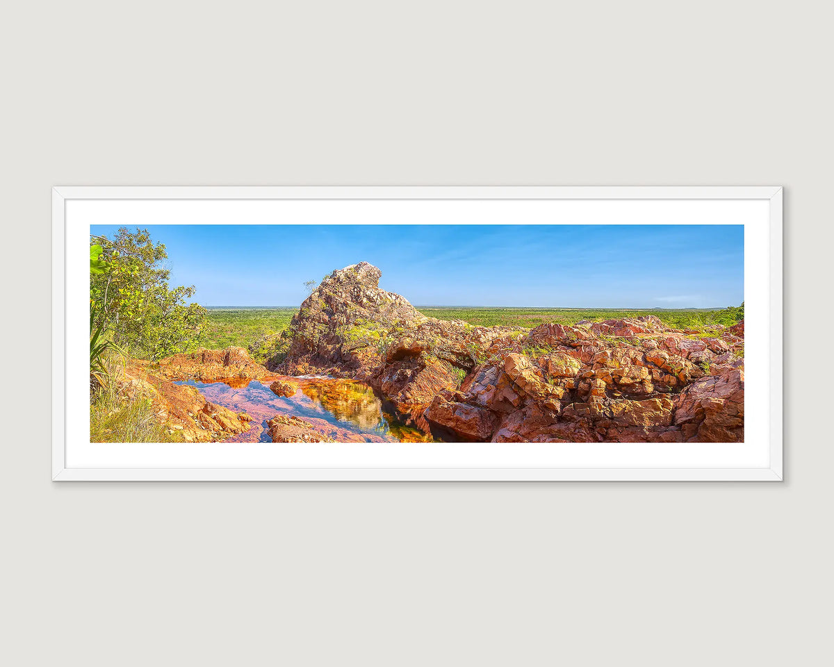 Framed landscape photograph of Wangi Falls, Litchfield National Park with rocks, trees and blue sky.