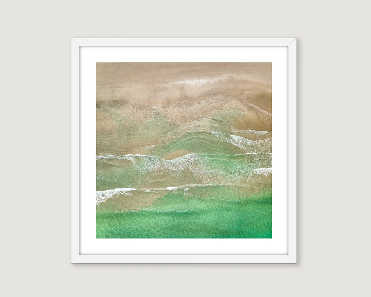 Framed abstract artwork of a beach with earthy tones on a light grey background.