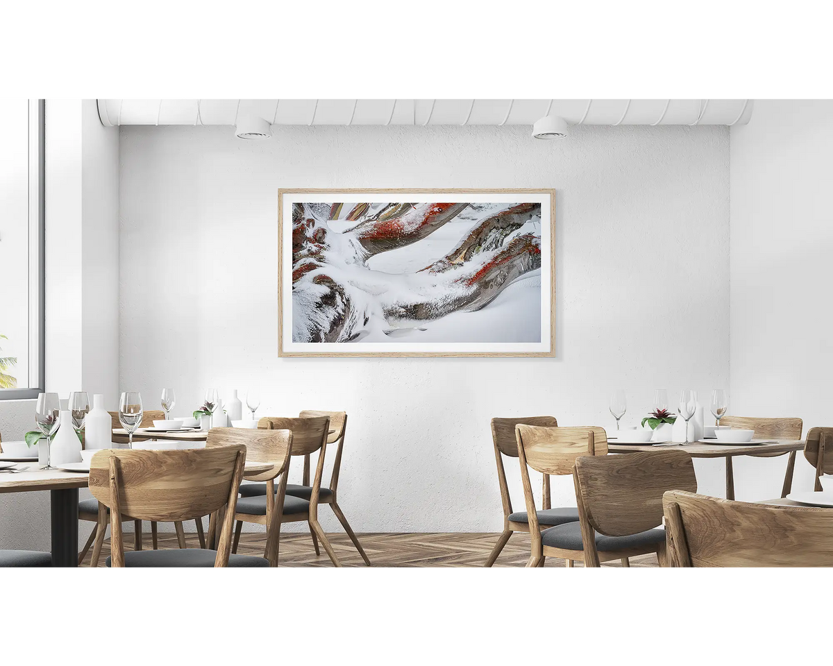 Weight. Wall art print of snow covered snow gum branches framed in a timber frame and hung above a couch.