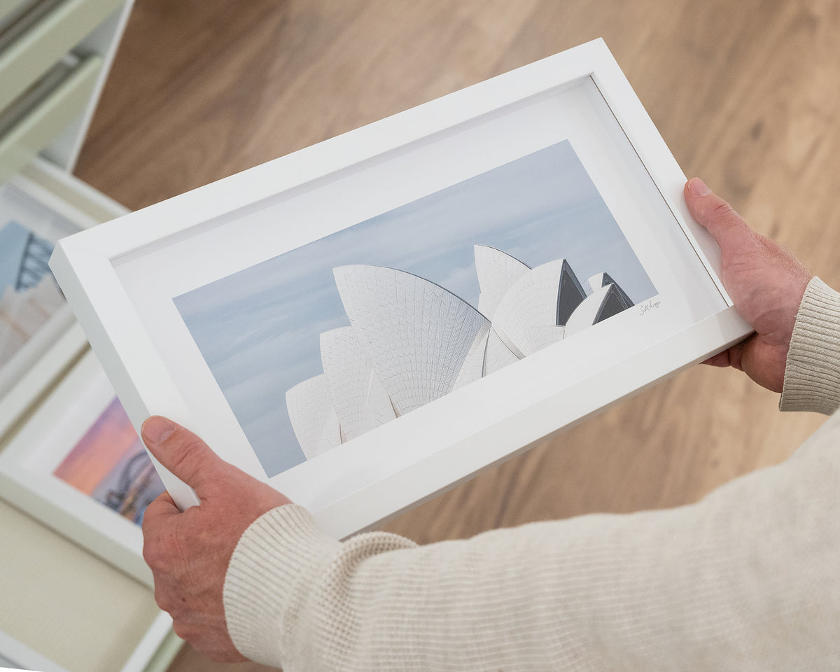 White Sails. Sydney Opera House small print with white frame, hand held in gallery.