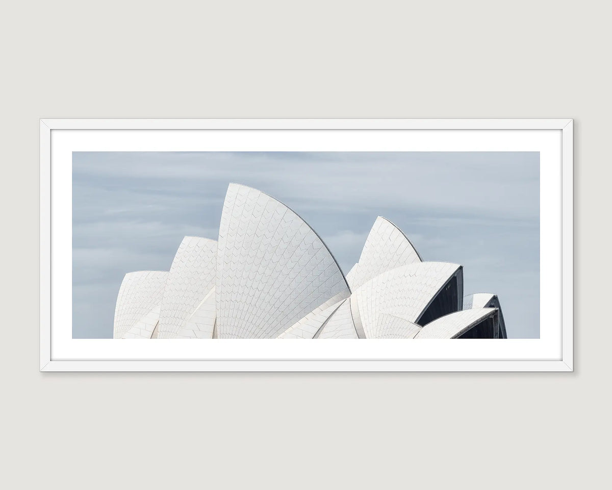 Framed photograph of the Sydney Opera House sails against a light blue sky.