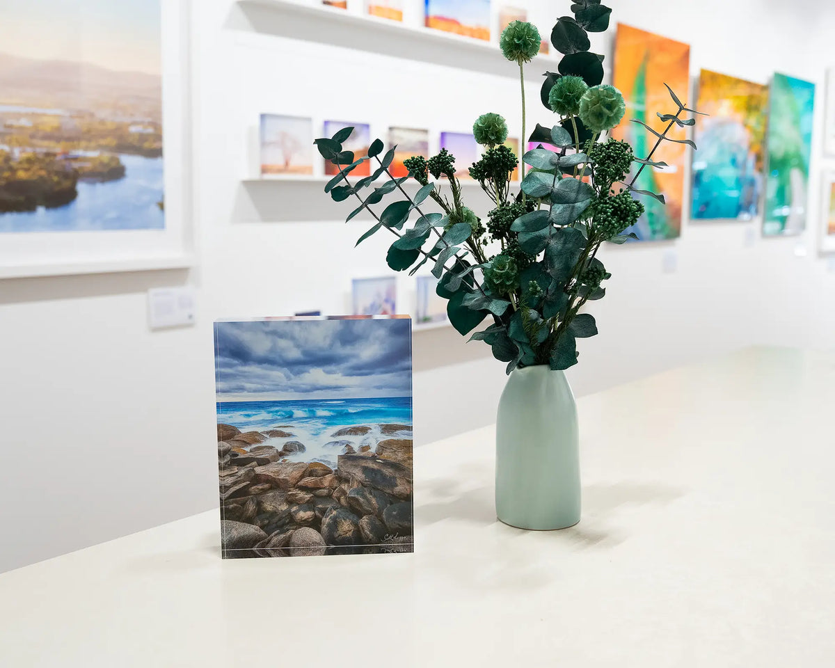 Wild West. Acrylic block of Redgate Leeuwin Naturaliste National Park, Western Australia, in gallery with floral arrangement.