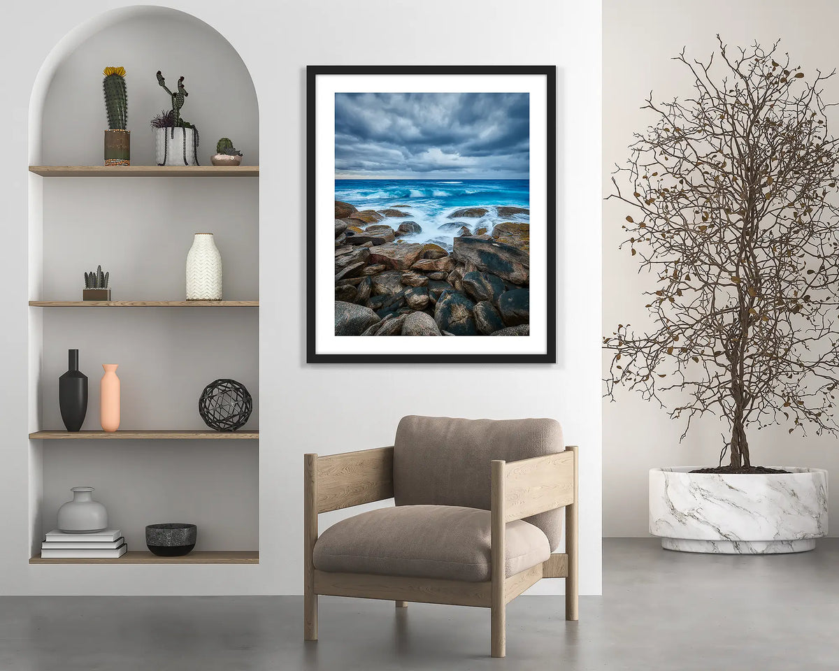Wild West. Coastal wall art print with a black frame hung above a chair. 