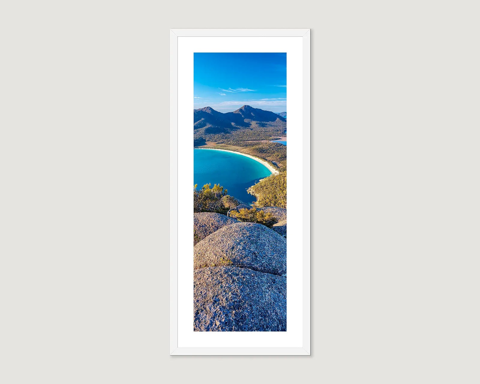 Framed artwork of a scenic landscape photograph of Wineglass Bay at sunrise.