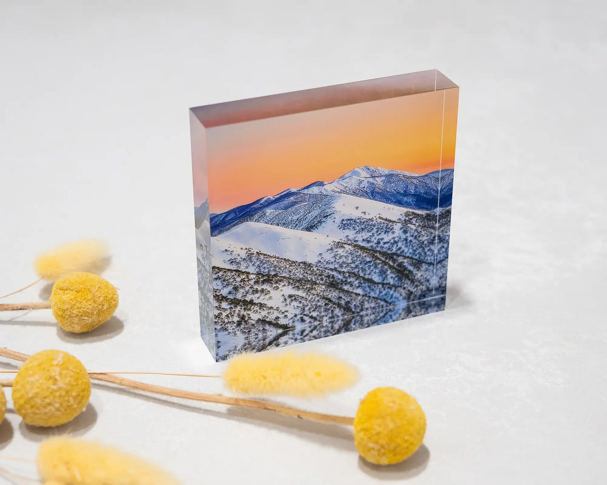 Winter Glow. Acrylic block of an orange sunrise over summit of Mount Feathertop, styled with dried flowers.
