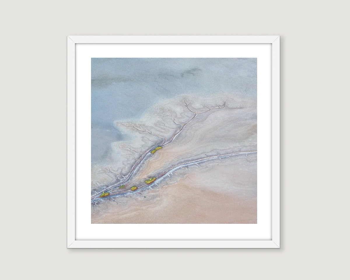 Framed abstract artwork of a desert landscape with a winding river.