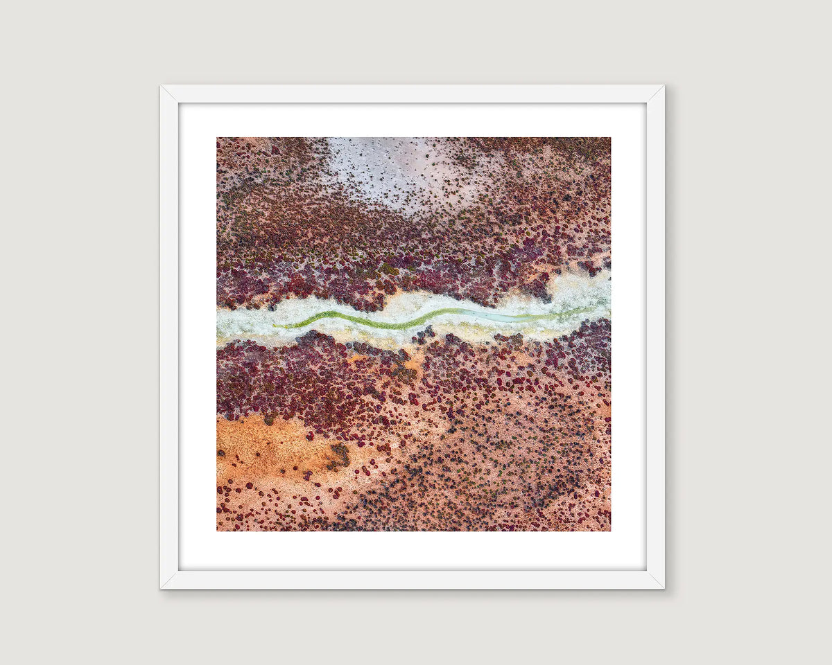 Framed abstract art print with earthy tones on a light grey background.