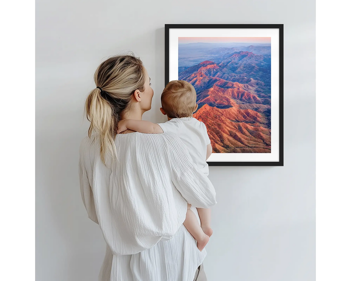 Wrinkles. Aerial photography artwork of Flinders Ranges with a black frame, being admired by a mother and baby. 