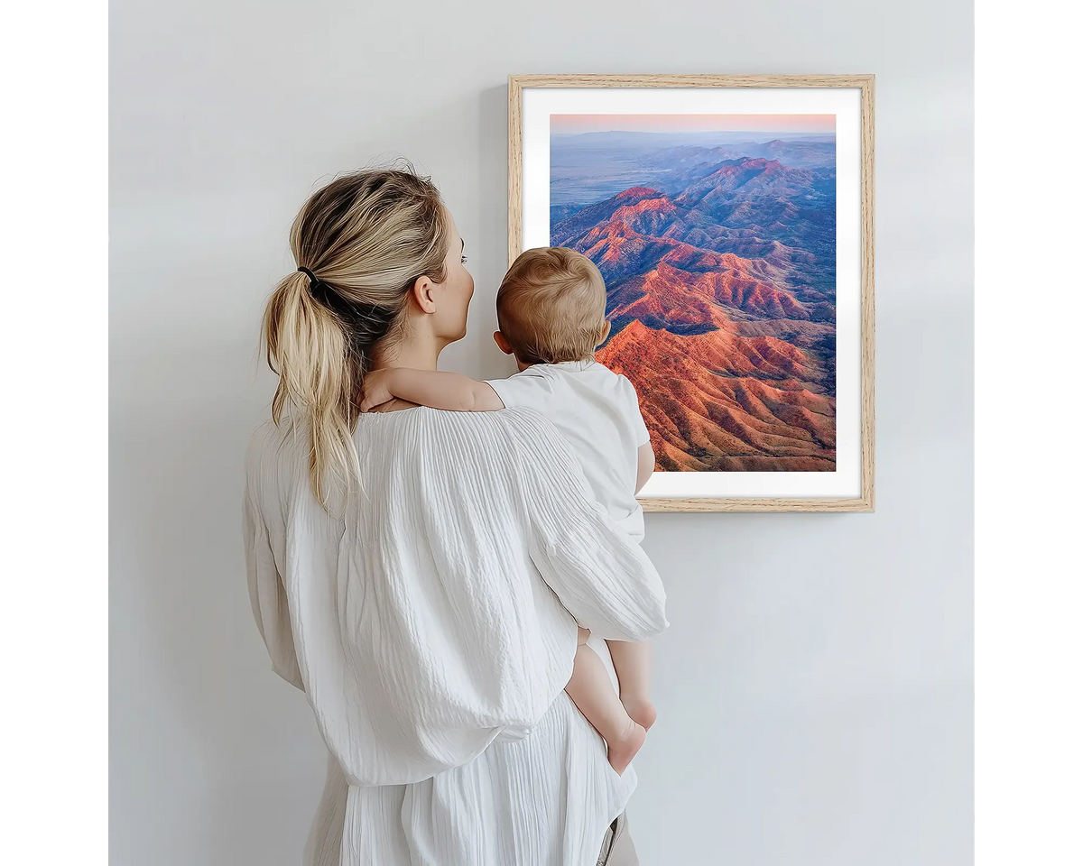Wrinkles. Aerial photography artwork of Flinders Ranges with a timber frame, being admired by a mother and baby. 